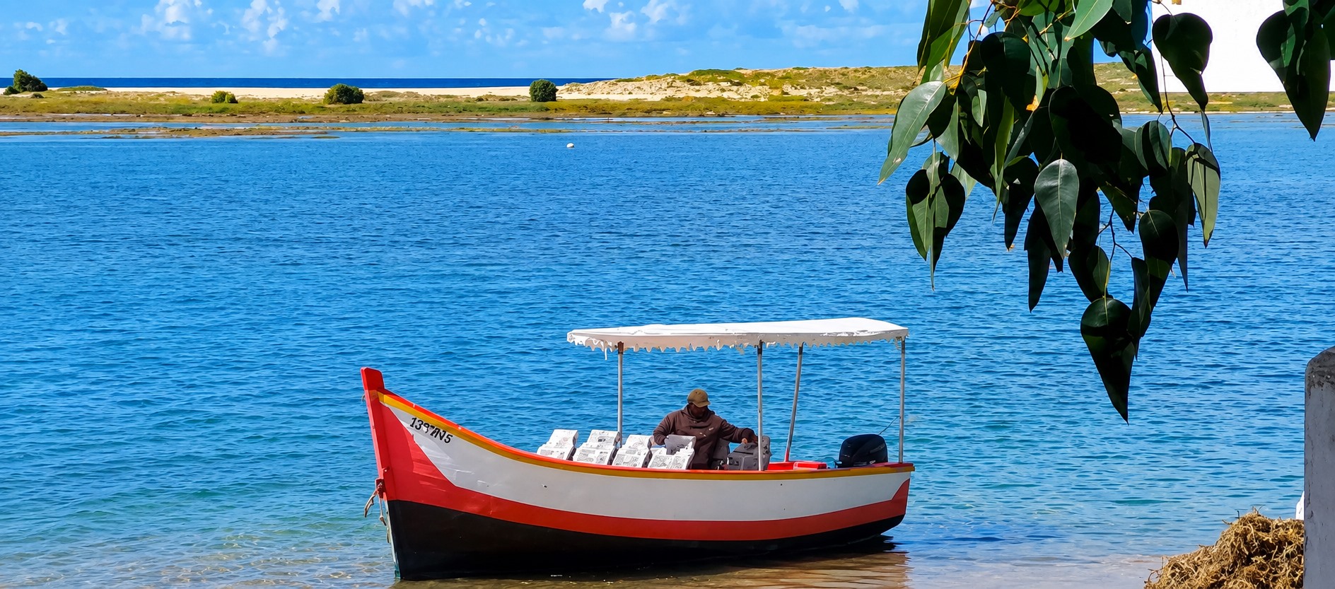Barque traditionnelle rouge sur les eaux paisibles de la lagune de Oualidia
